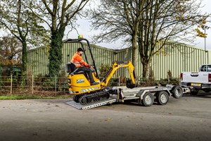 JCB 8008E micro excavator being loaded onto a trailer ready for transportation. 